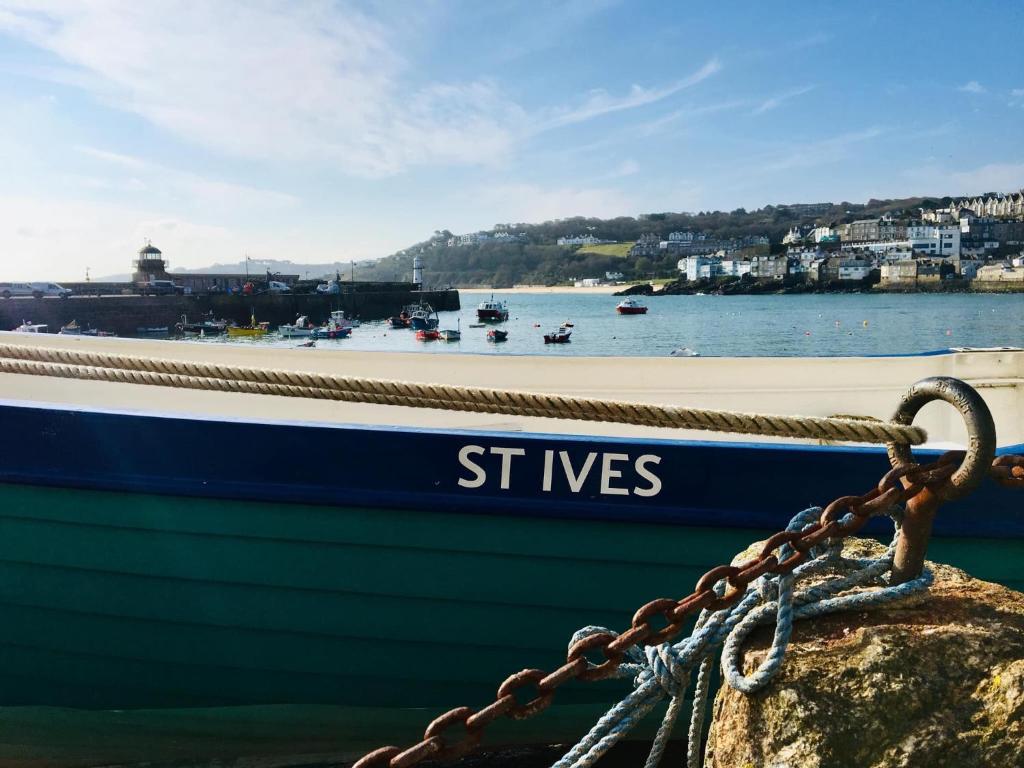 圣艾夫斯Waves End, St Ives, Hot tub and Parking的一条船被绑在石头上,上面写着灰泥
