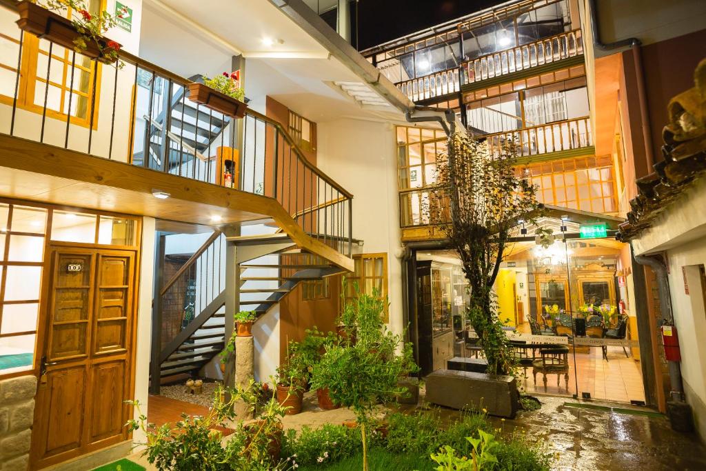 库斯科MOAF Cusco Boutique Hotel的一座室内庭院,里面设有楼梯和植物