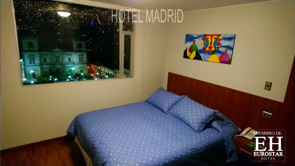 拉巴斯Hotel Madrid的一间卧室设有蓝色的床和窗户。