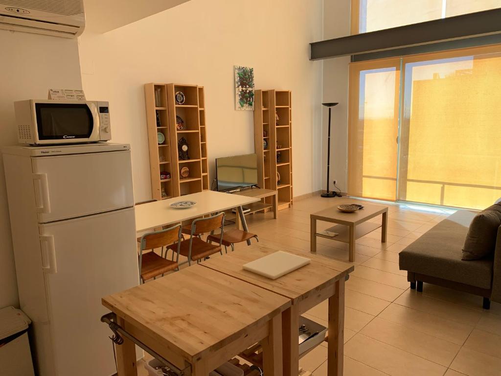 阿尔考空Apartamento de 1 dormitorio, Ático 4PAX的厨房以及带冰箱和桌子的客厅。