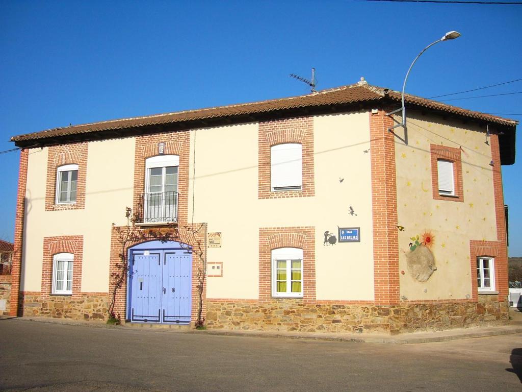 CarnerosHotel Rural La Rosa de los Tiempos的一座带蓝色门的旧砖砌建筑