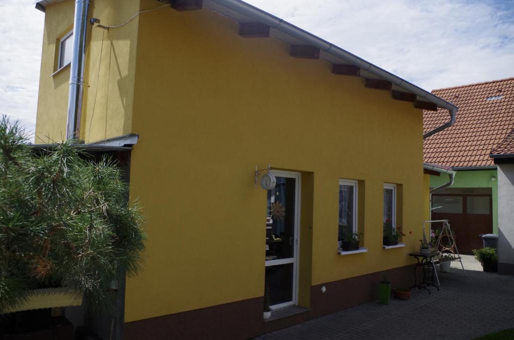 PoštornáU Klárinky的黄色的建筑,设有门和庭院
