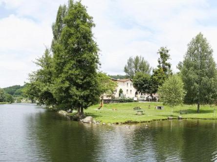 富瓦Hotel du Lac Foix的湖畔树木的房子