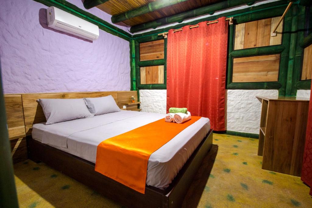 莫姆皮切Aparthotel Oleaje的一间卧室配有一张带橙色毯子的床