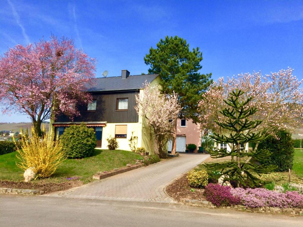 克罗夫GästeHaus Auler Hof的一座种有鲜花的树和车道的房子