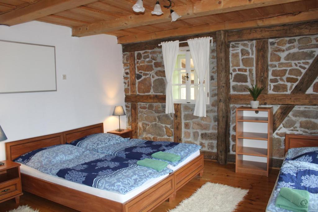 洛克特Penzion Modrý Svět的一间卧室设有一张床和石墙