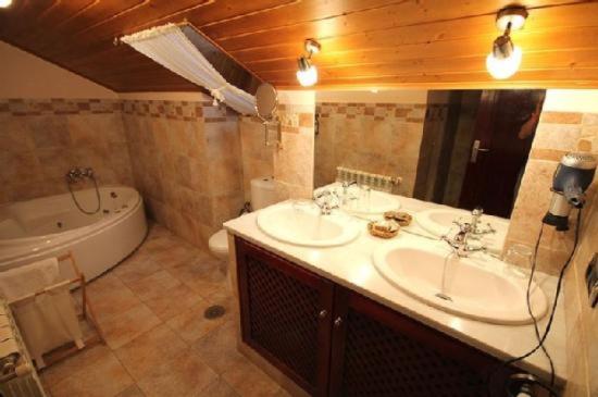 Navia de SuarnaCasa Suarna的一间带两个盥洗盆、浴缸和卫生间的浴室