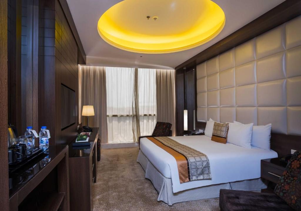 利雅德利雅得格洛丽亚酒店的酒店客房设有床和黄色天花板