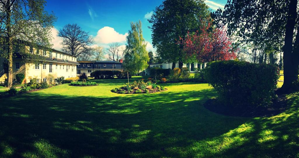 勒伯尔姆瑞兹公园菲瑞恩皇宫酒店的一座带房子的院子和一座树木繁茂的花园