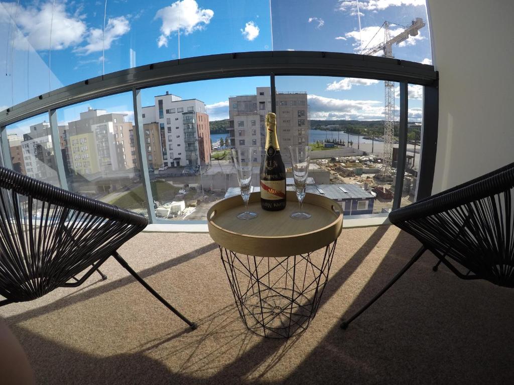 于韦斯屈莱Soolo 6th floor lake view的窗户前的桌子上放着一瓶葡萄酒