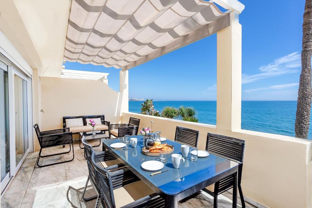 EsteponaBeach View Playa Del Moral的一间带桌椅的海景用餐室
