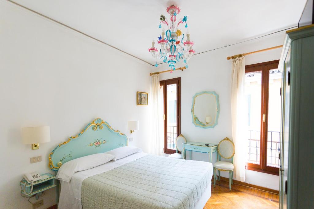 威尼斯瑟瑞尼斯玛酒店的白色卧室配有床和镜子