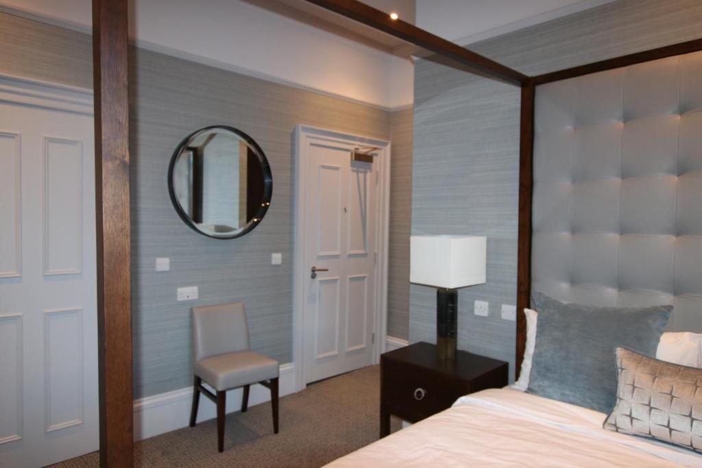 坎伯诺尔德卡斯特卡里豪斯酒店的一间卧室配有一张床、镜子和椅子