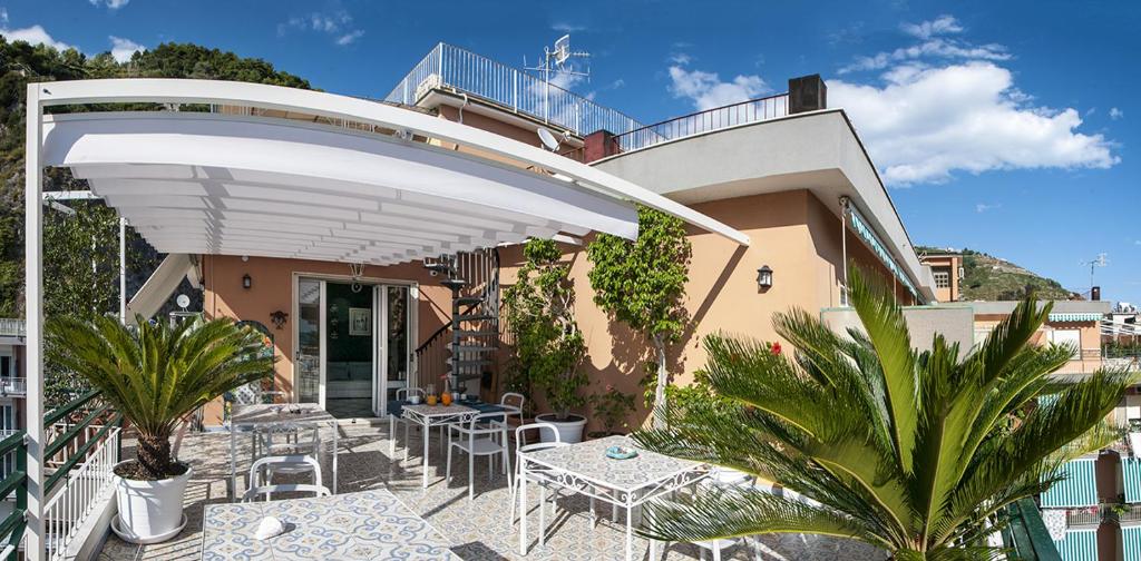 马奥莱B&B Amalfè的一个带桌椅的白色遮阳伞下庭院
