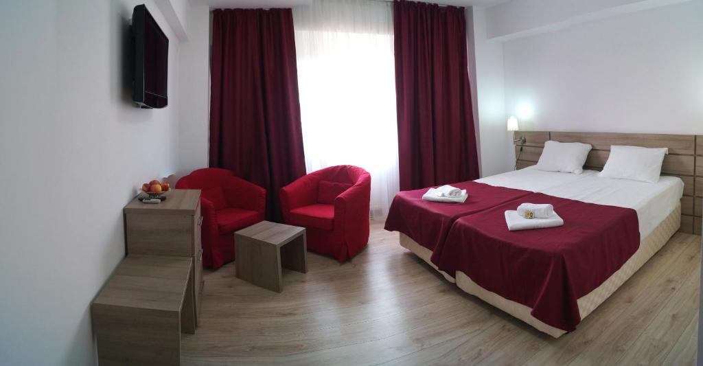 奥托佩尼奥托佩尼酒店的酒店客房,配有一张床和一张红色椅子