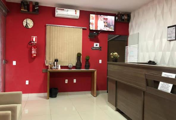 戈亚尼亚POUSADA EXECUTIVE EXPRESS的厨房设有红色的墙壁、一个柜台和一个消防栓