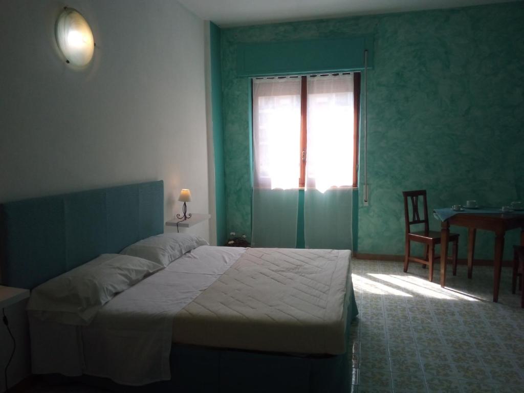 拉蒂纳Bed & Breakfast LA TERRAZZA的一间卧室配有一张床、一张桌子和一个窗户。