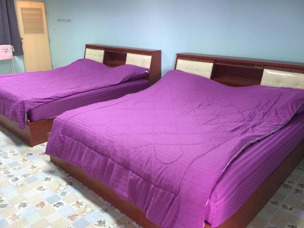 梭桃邑Navy Home Sattahib的客房内的两张床和紫色床单