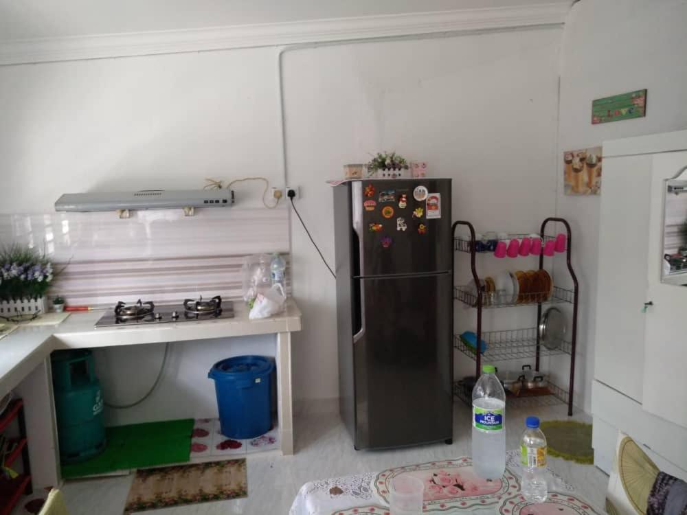 玻璃市港口Anis Homestay Kuala Perlis的一间厨房,里面配有黑色冰箱