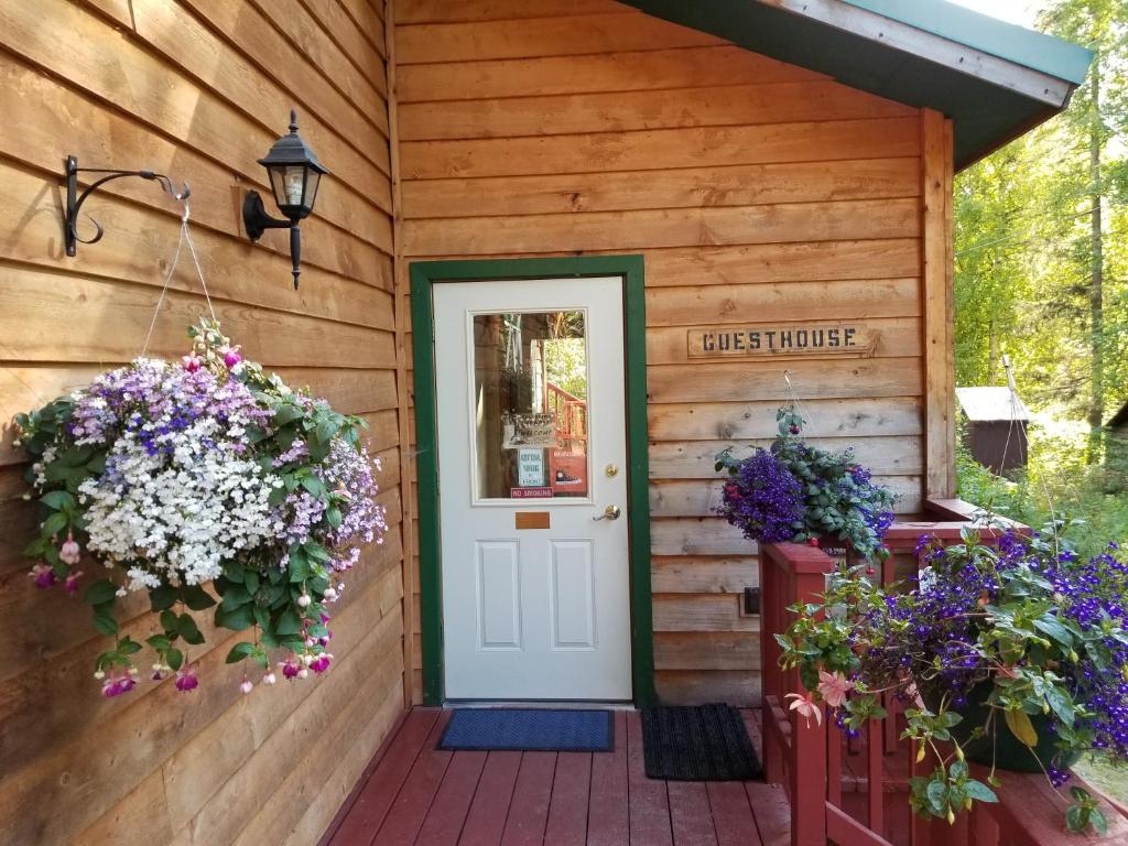 塔尔基特纳Talkeetna Hideaway的鲜花盛开的木屋前门