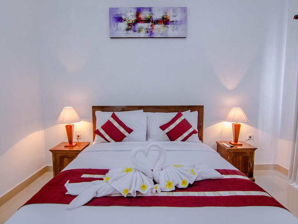 珀尼达岛Sambu Bungalow的一间卧室配有白色床和2个床头柜