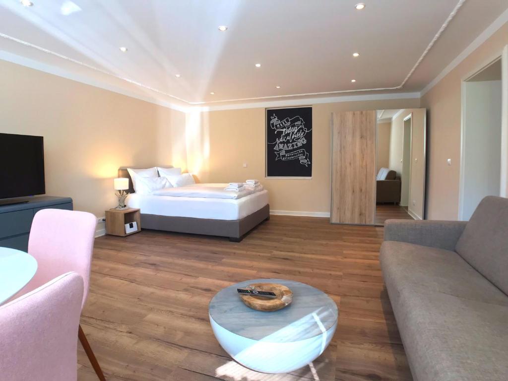 波茨坦Amaroo - Apartments Potsdam “Alexandrowka”的一间卧室配有一张床、一张沙发和一张桌子