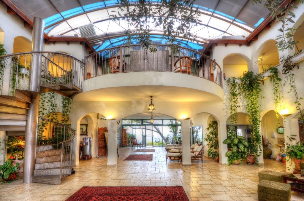 埃米瑞姆阿米雷哈加里尔精品酒店的大型大堂设有玻璃天花板和植物