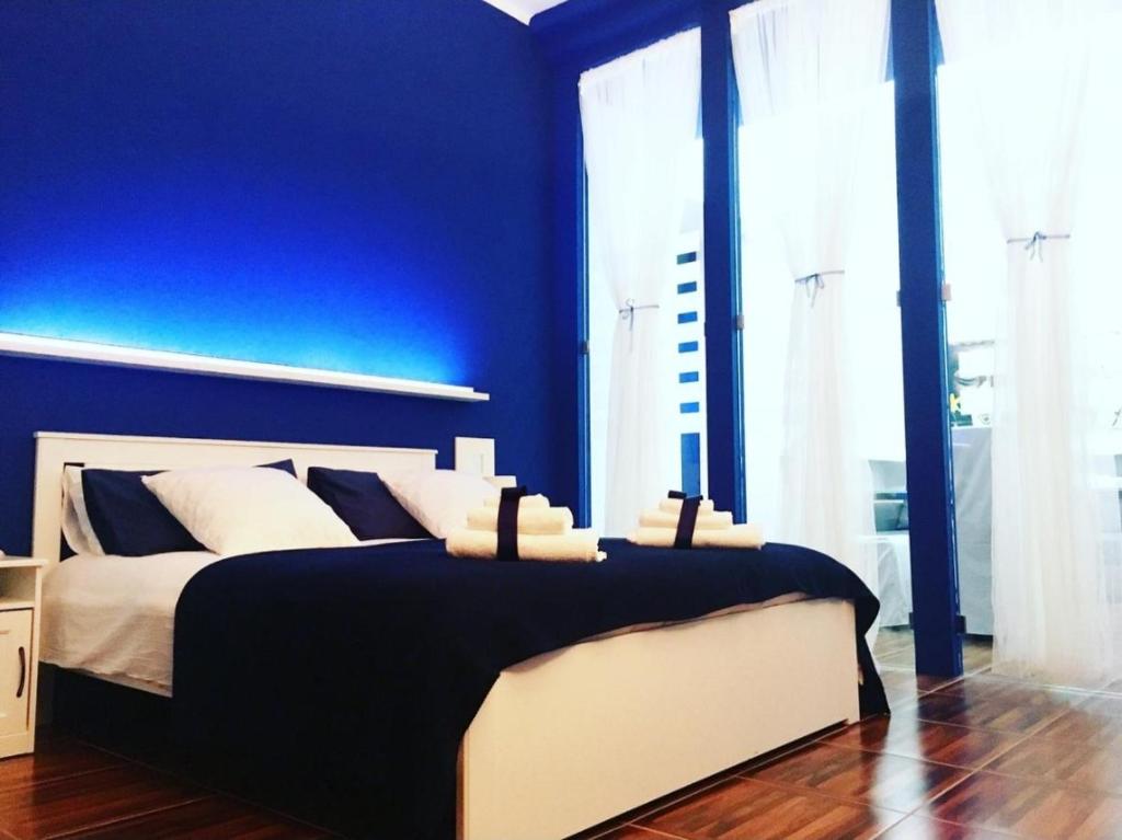 焦维纳佐Casadamare Holiday Home的蓝色的卧室,配有一张蓝色墙壁的床