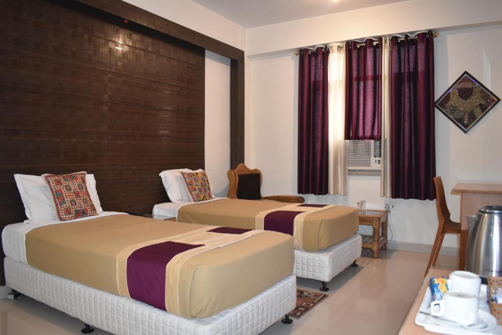 菩提伽耶Hotel Bodh Vilas的酒店客房设有两张床和一张桌子。
