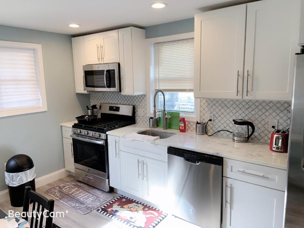巴尔的摩Nice bedroom next fells point的厨房配有白色橱柜和炉灶烤箱。