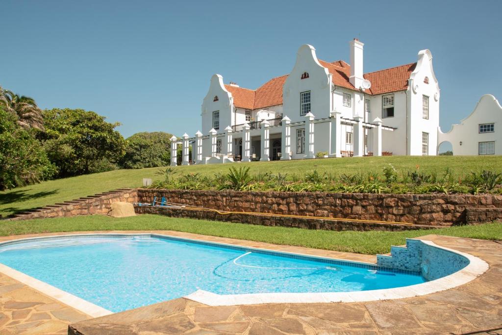彭宁顿Botha House的一座大房子,前面设有一个游泳池