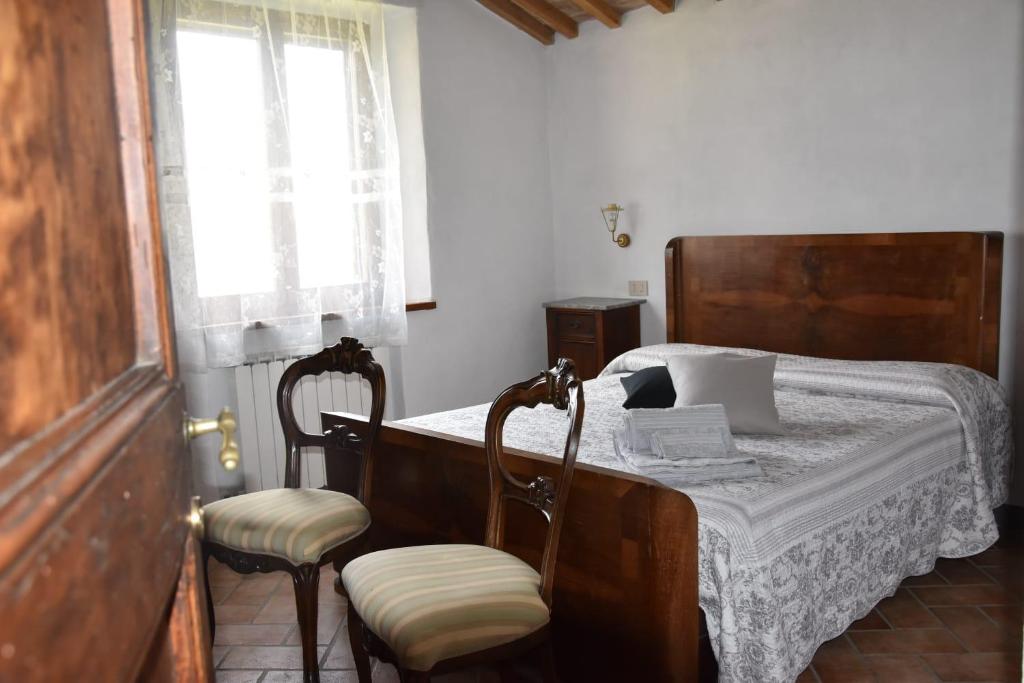 蒙塔尔奇诺韦基亚门度假屋的一间卧室配有一张带两把椅子的床和一扇窗户