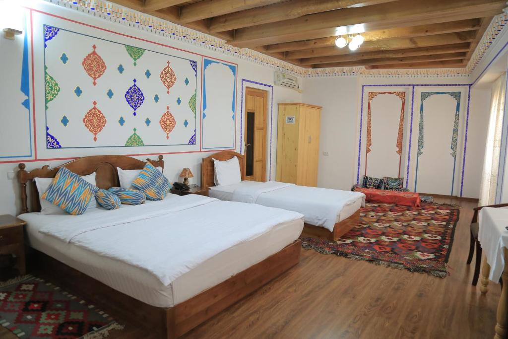 布哈拉As-Salam Boutique Hotel的一间卧室设有两张床,墙上挂着一幅画