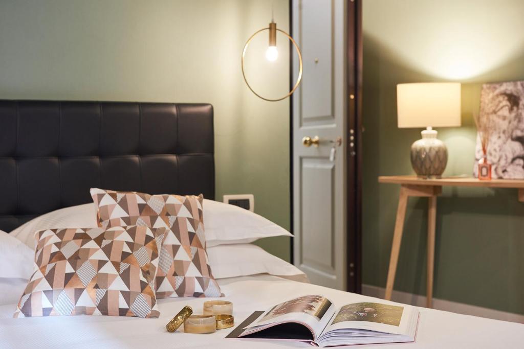 佛罗伦萨莱奥波尔多酒店的一间卧室配有一张带书籍和灯的床
