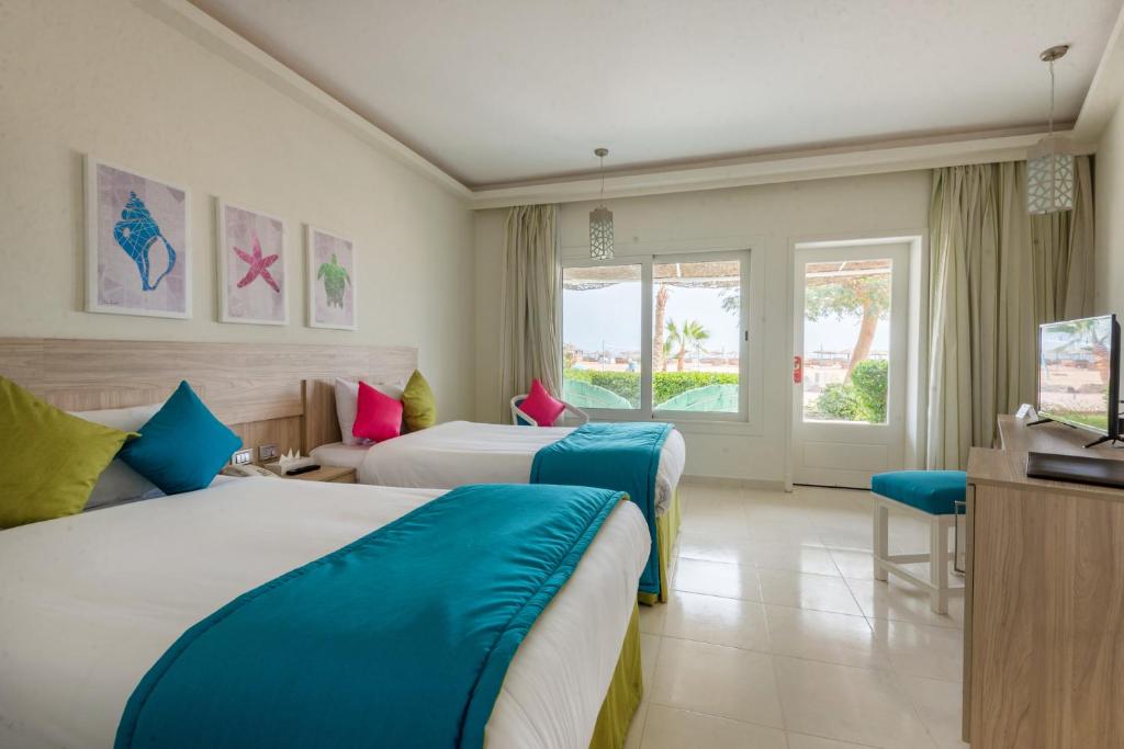 赫尔格达Shams Lodge的酒店客房设有两张床和电视。
