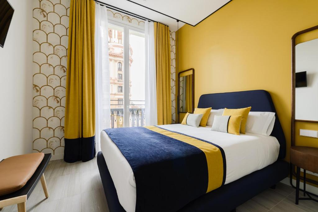 马德里Smartrental Collection Gran Vía Centric的酒店客房设有床和窗户。