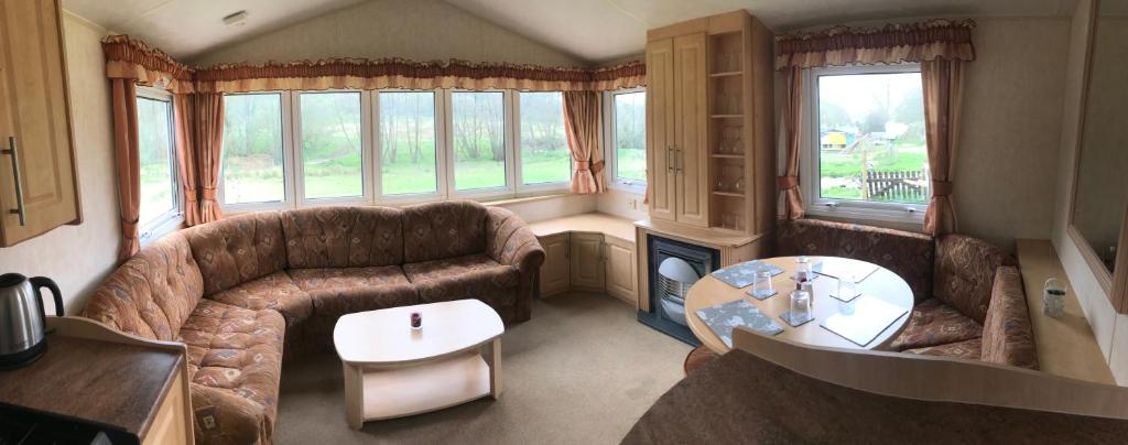 MontacuteYeovil Accomodation Business & Pleasure, 2 dble Bedrooms, Bathroom en-suite, Kitchen, Lounge, Diner, Garden, 365 acres Forest & Streams, Workers huts available with lrge Van parking的客厅配有沙发和桌子