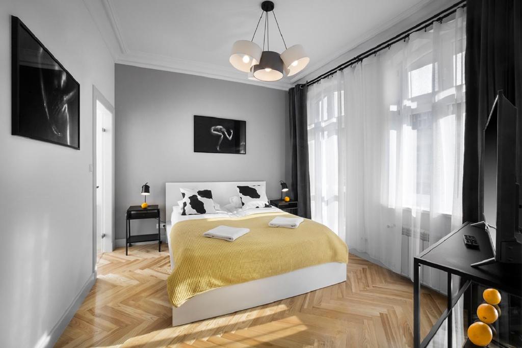 波兹南橘园公寓的一间卧室配有一张带黄色毯子的大床