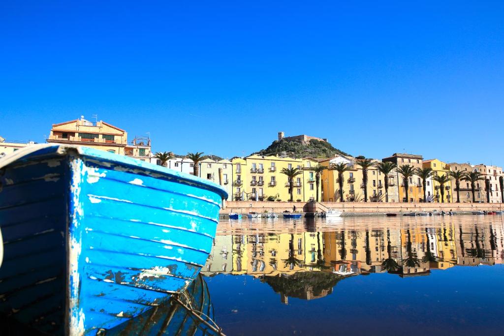 博萨科尔特费欧利塔艾尔伯格迪富索酒店的坐在城市前水中的蓝色小船