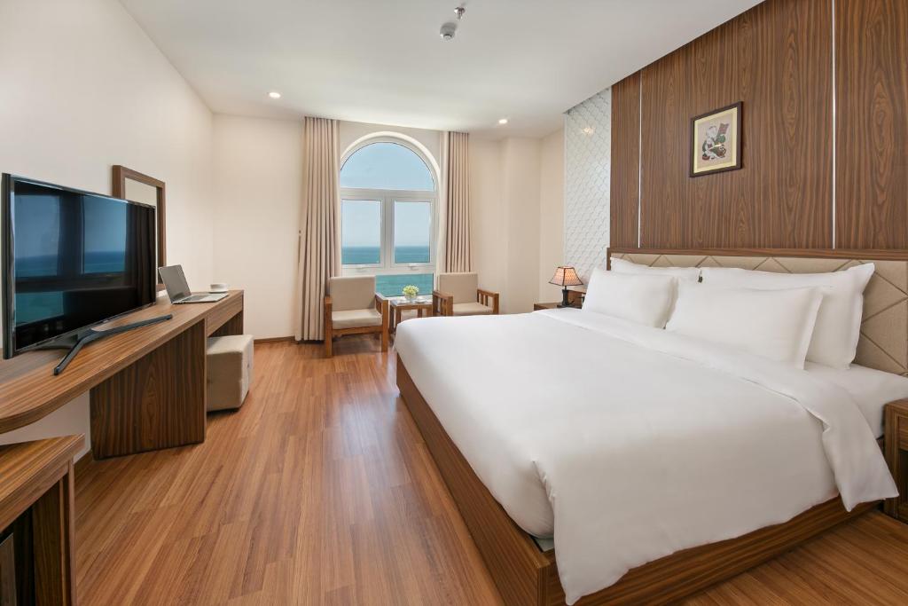 岘港De Lamour Hotel的卧室配有一张白色大床和电视。