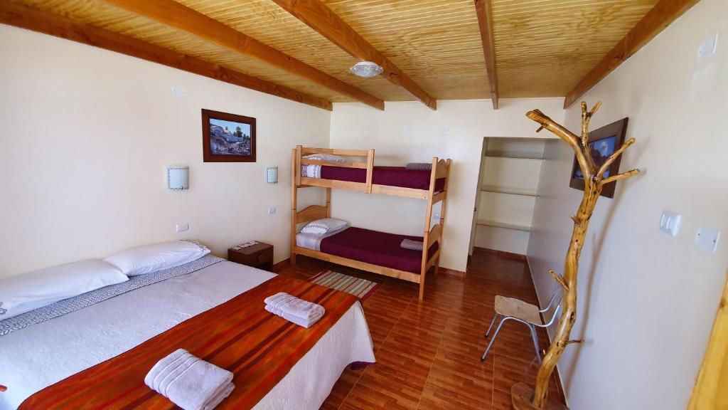 圣佩德罗·德·阿塔卡马Hostal Ckamai的一间卧室设有两张双层床和一张桌子