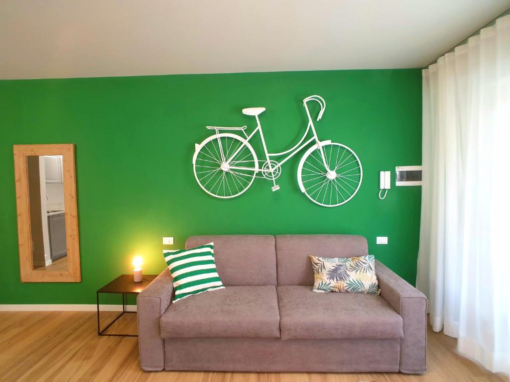 贝加莫Donizetti Residence的客厅配有沙发,自行车在绿色的墙上