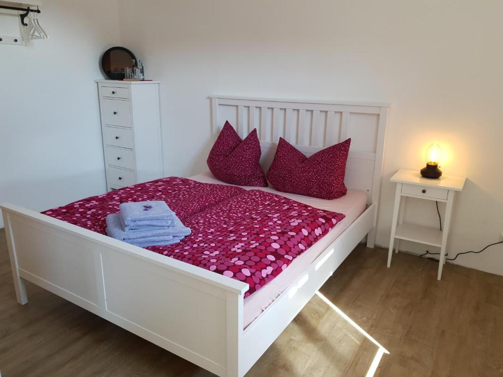 卢肯瓦尔德Turmklause的卧室配有带红色枕头的白色床