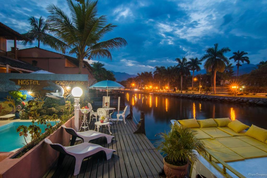 帕拉蒂Pousada Casa do Rio Hostel - 8 min do Centro Hístorico - Passeio de Barco com saída da Pousada -Pago a parte- Perto das Praias e Beira Rio的河畔甲板上配有沙发和桌椅
