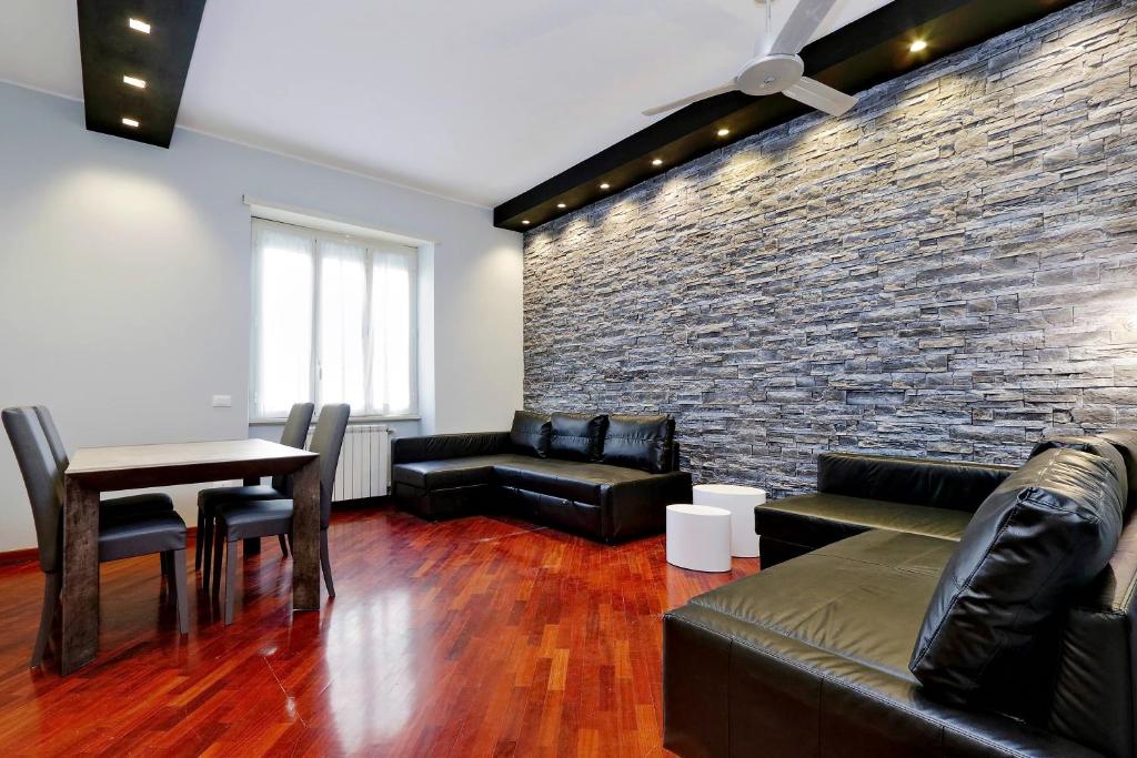 罗马蓝宝石公寓的客厅配有皮革家具和砖墙
