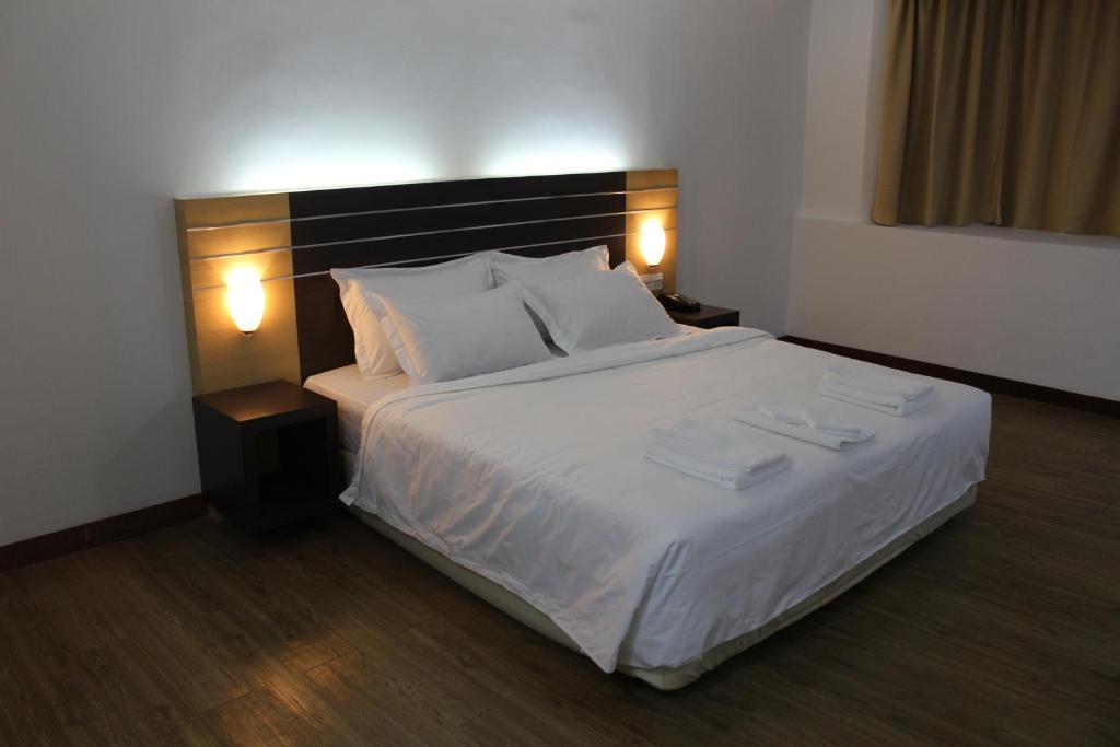 拉布安Sara Hotel的卧室配有一张带白色床单和枕头的大床。