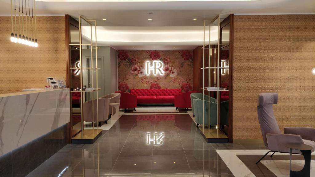 的里雅斯特罗马酒店的酒店大堂中间设有红色沙发