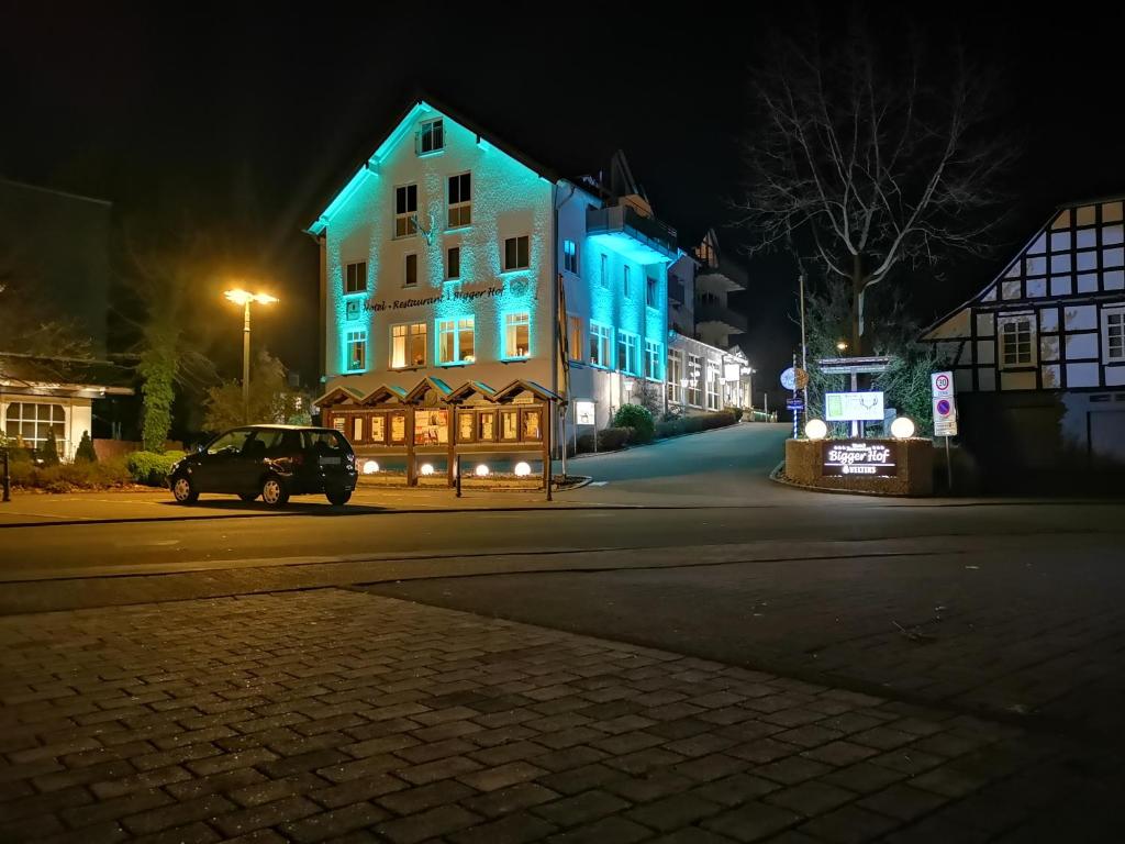 奥尔斯贝格Hotel Bigger Hof - Wirtshaus Platzhirsch am Jahnplatz的停在有蓝色灯光的房子前的汽车