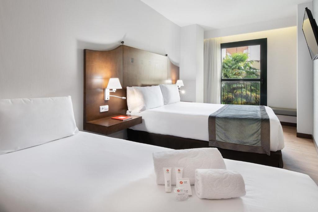 卡塞雷斯卡塞雷斯伊科斯阿戈拉酒店的酒店客房设有两张床和窗户。