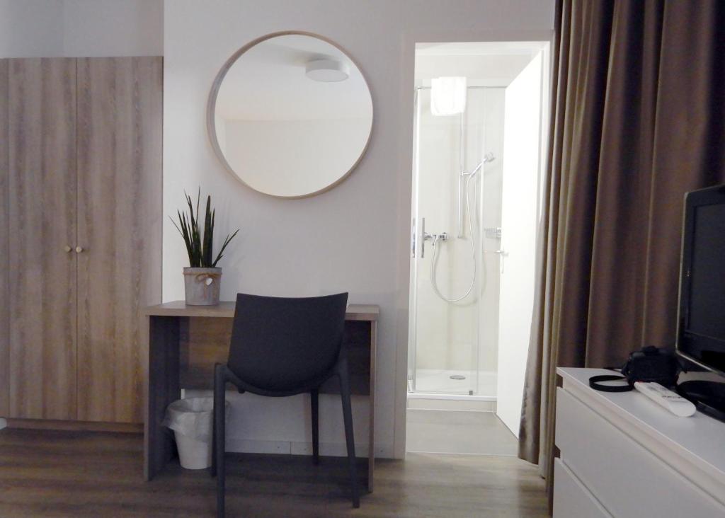 纳沙泰尔勒克鲁斯酒店的浴室设有一张带镜子和椅子的桌子